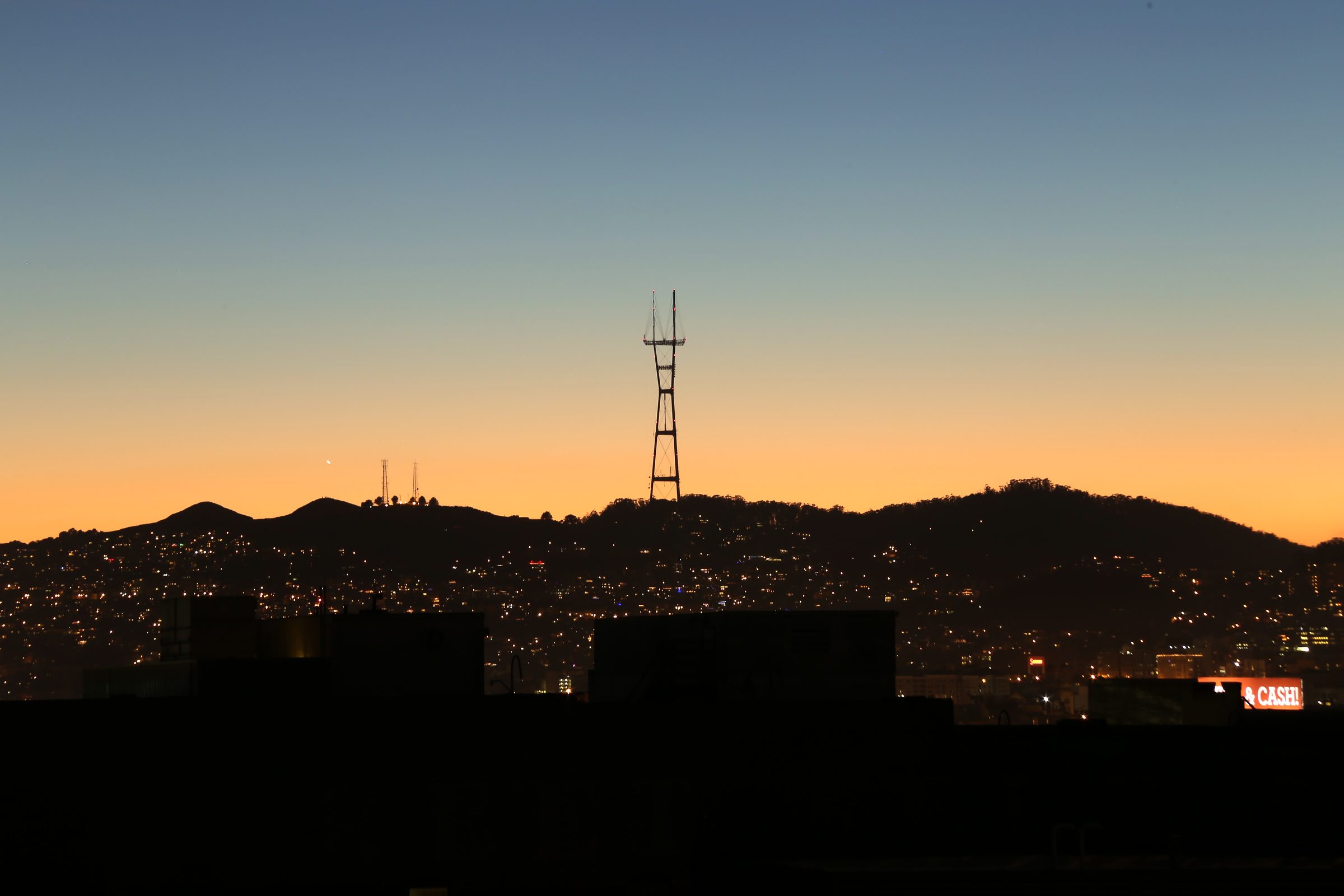 Sutro Tower and city silhouette against a gold dusk rim.