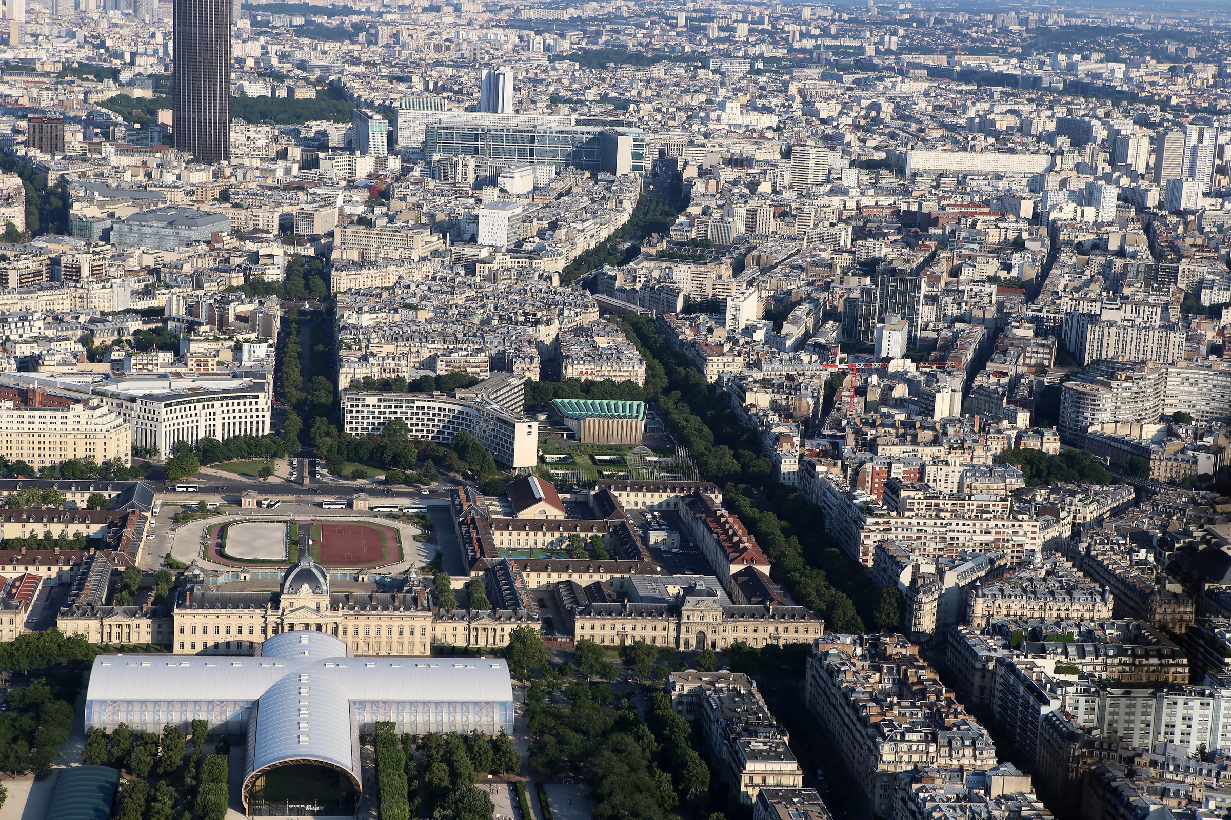 Aerial Paris rooftops and streets of dense stone architecture.