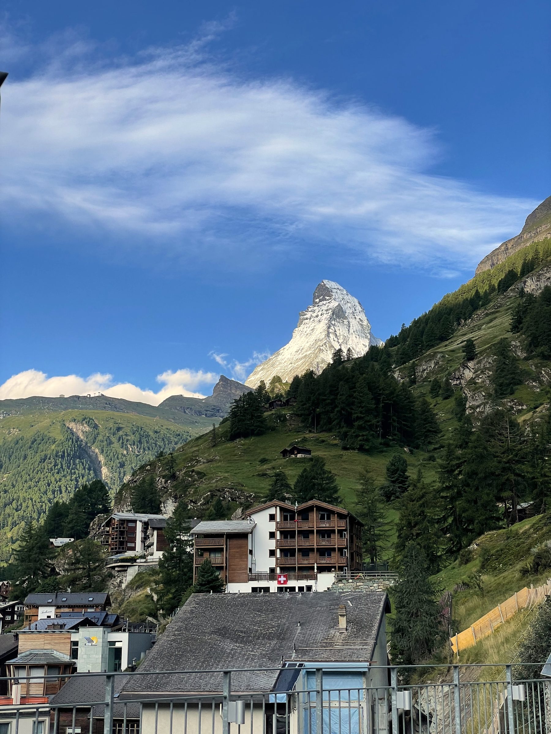Mountain peak rising above hillside village rooftops.
