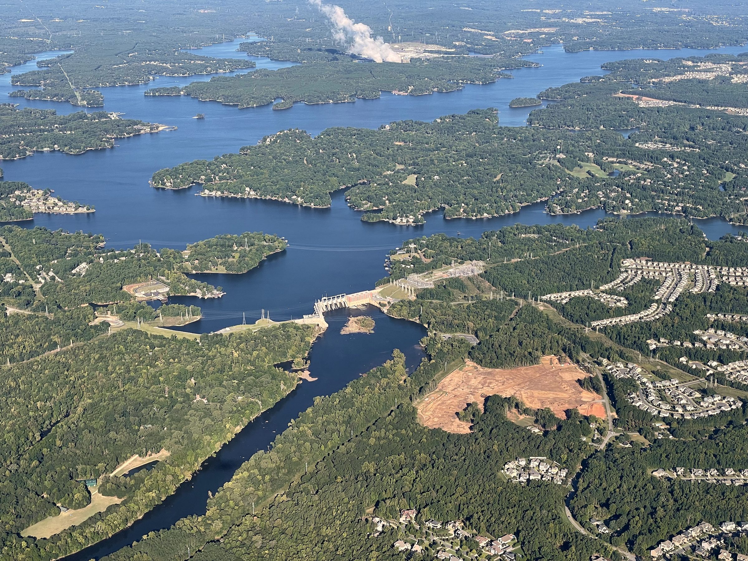 Aerial winding river through dense forested landscape.