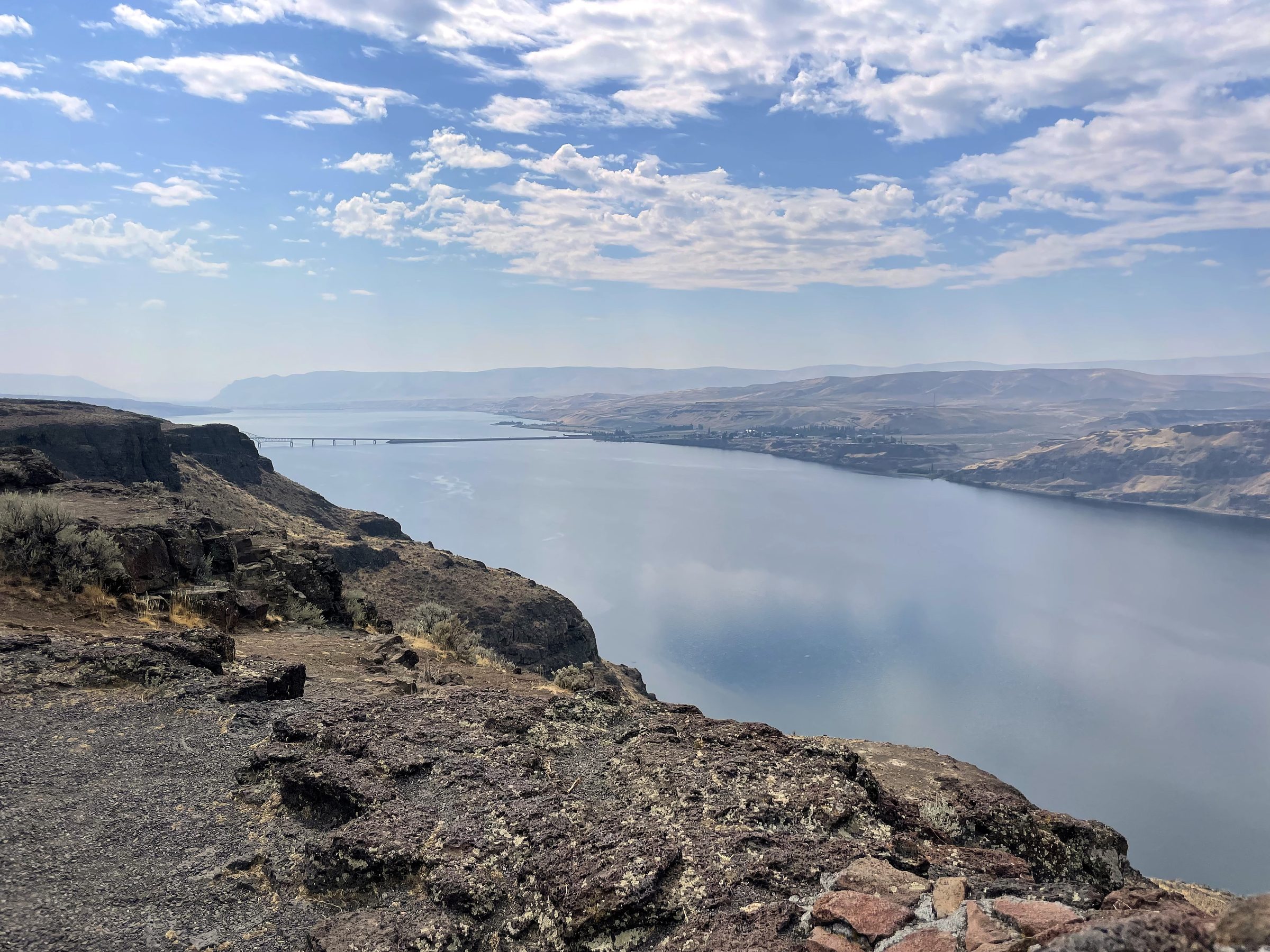 Cliff edge overlooking a silver river through rocky country.