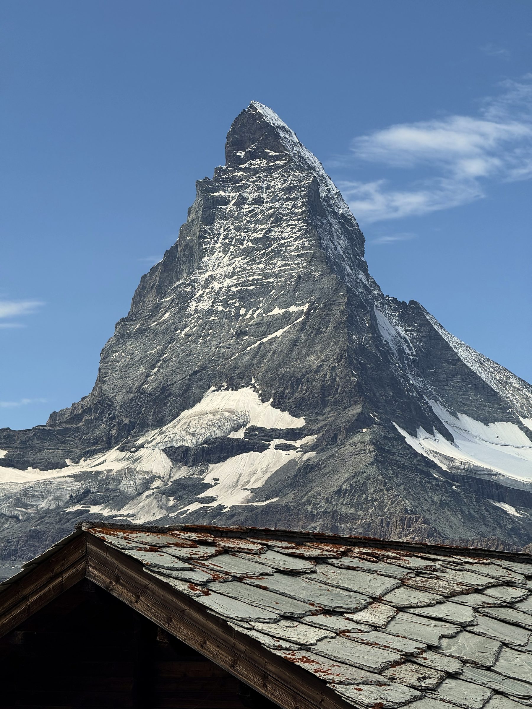 Matterhorn rising over the edge of a stone-shingled alpine roof.