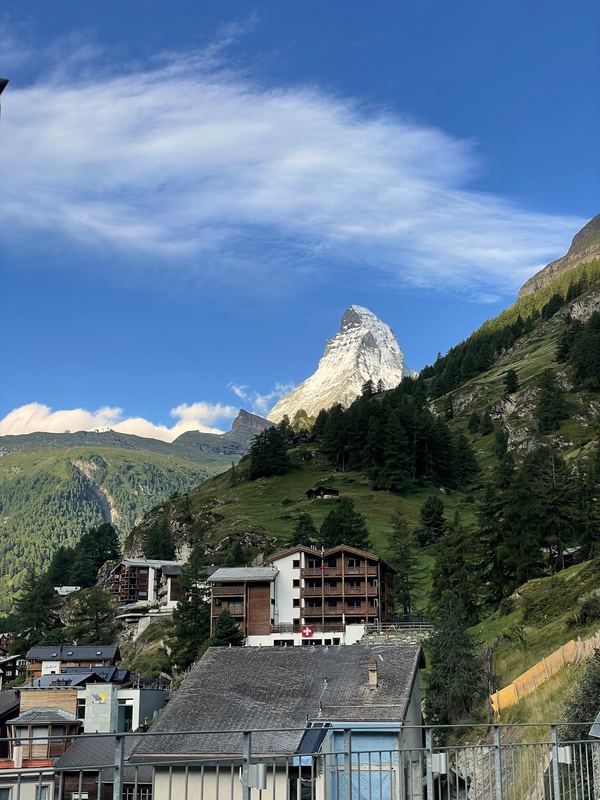Mountain peak rising above hillside village rooftops.