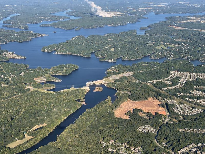 Aerial winding river through dense forested landscape.