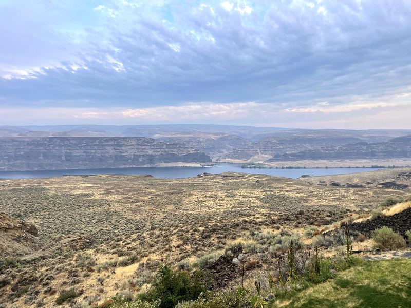 Mackerel-pattern sky over a basalt gorge and wide river.