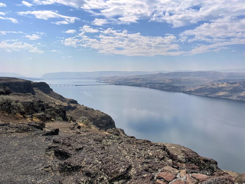 Cliff edge overlooking a silver river through rocky country.