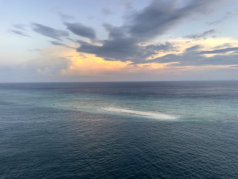 Calm dusk ocean with a single glowing brushstroke of light.